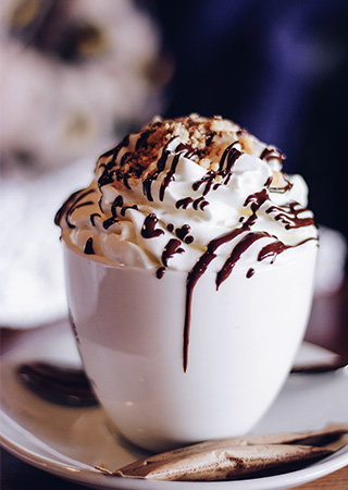 Sorvete dentro de uma xícara branca com cobertura de chocolate
